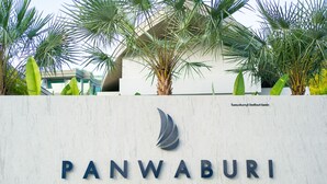 A sign for Panwaburi Beachfront Resort with palm trees in the background. - Panwaburi Beachfront Resort (Wichit)