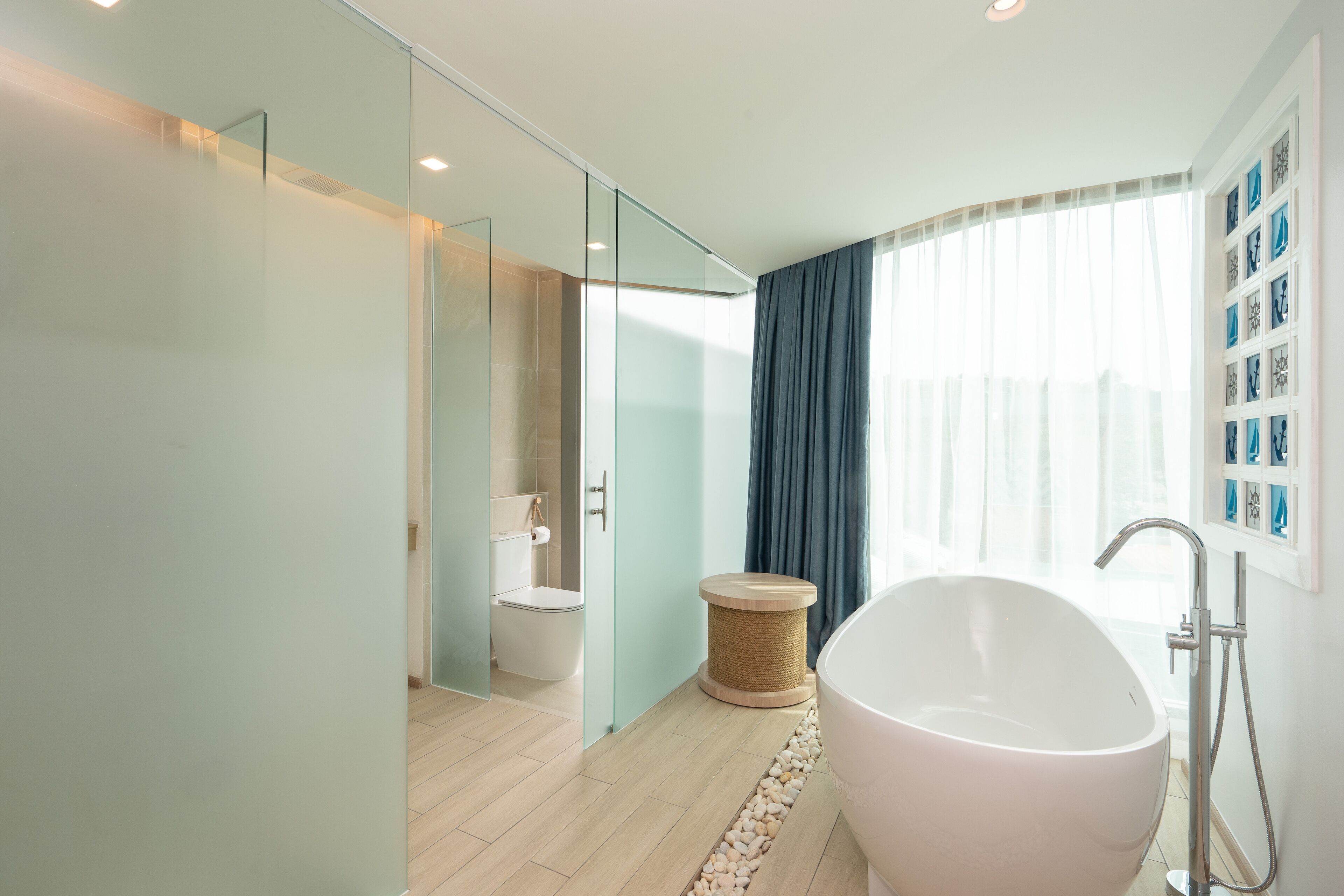 A modern bathroom with a freestanding bathtub, a glass shower enclosure, and a toilet.