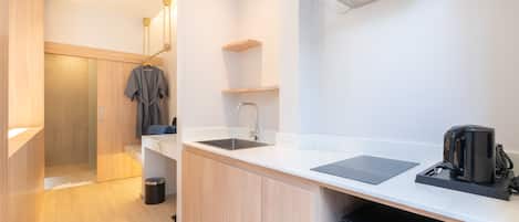 A modern kitchen with a sink, countertop, and coffee maker.
