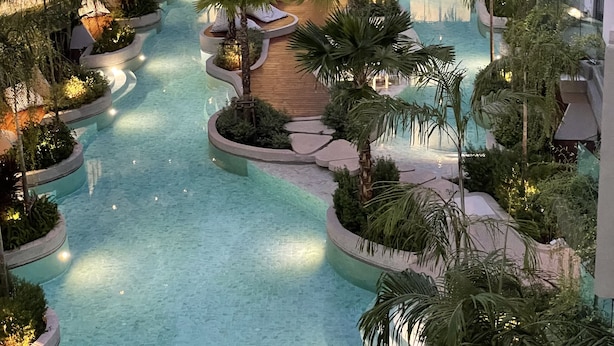 A multi-level indoor pool with tiered seating and surrounding greenery. - Panwaburi Beachfront Resort (Wichit)