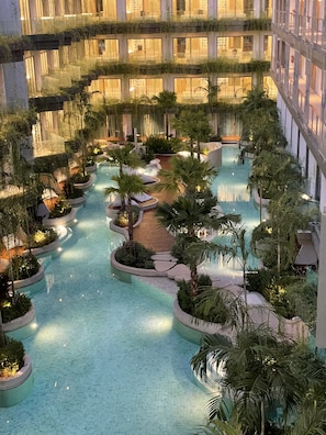Une piscine intérieure à plusieurs niveaux, dotée de gradins et entourée de verdure.