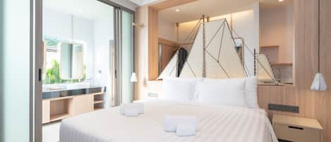 A modern hotel room with a large bed, a walk-in closet, a large mirror, and a view of the outdoors.