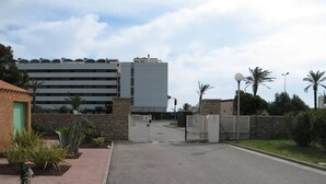 A gated parking area with a building in the background. - Charming 2BR Villa with Pool, Tennis & BBQ - 200m from Beach, Saint-Cyprien (Saint-Cyprien)