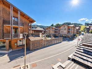 Ein Holzgebäude mit Balkonen und einer Straße davor.