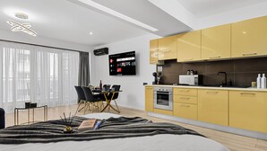 A modern bedroom with a large bed, a bedside table, and a TV mounted on the wall. - InCity Charming Studio (Bucharest)