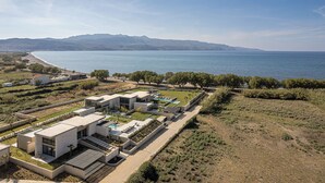 Un moderno complejo residencial con piscina, zonas ajardinadas y vistas al mar y a la montaña.