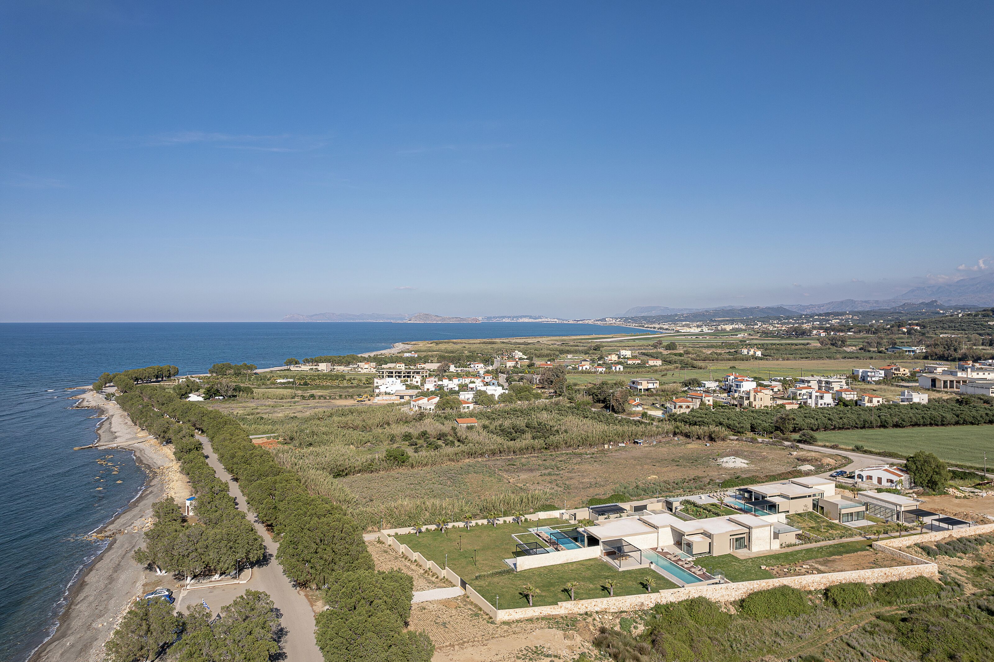 Une zone côtière comprenant une plage, une piscine et plusieurs bâtiments.
