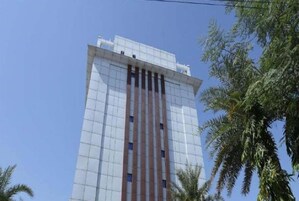 Um edifício alto e moderno com fachada em grade e linhas verticais.