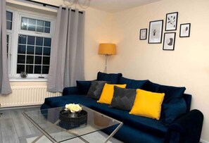 Relax in this inviting living room with a sofa, coffee table, and floor lamp.