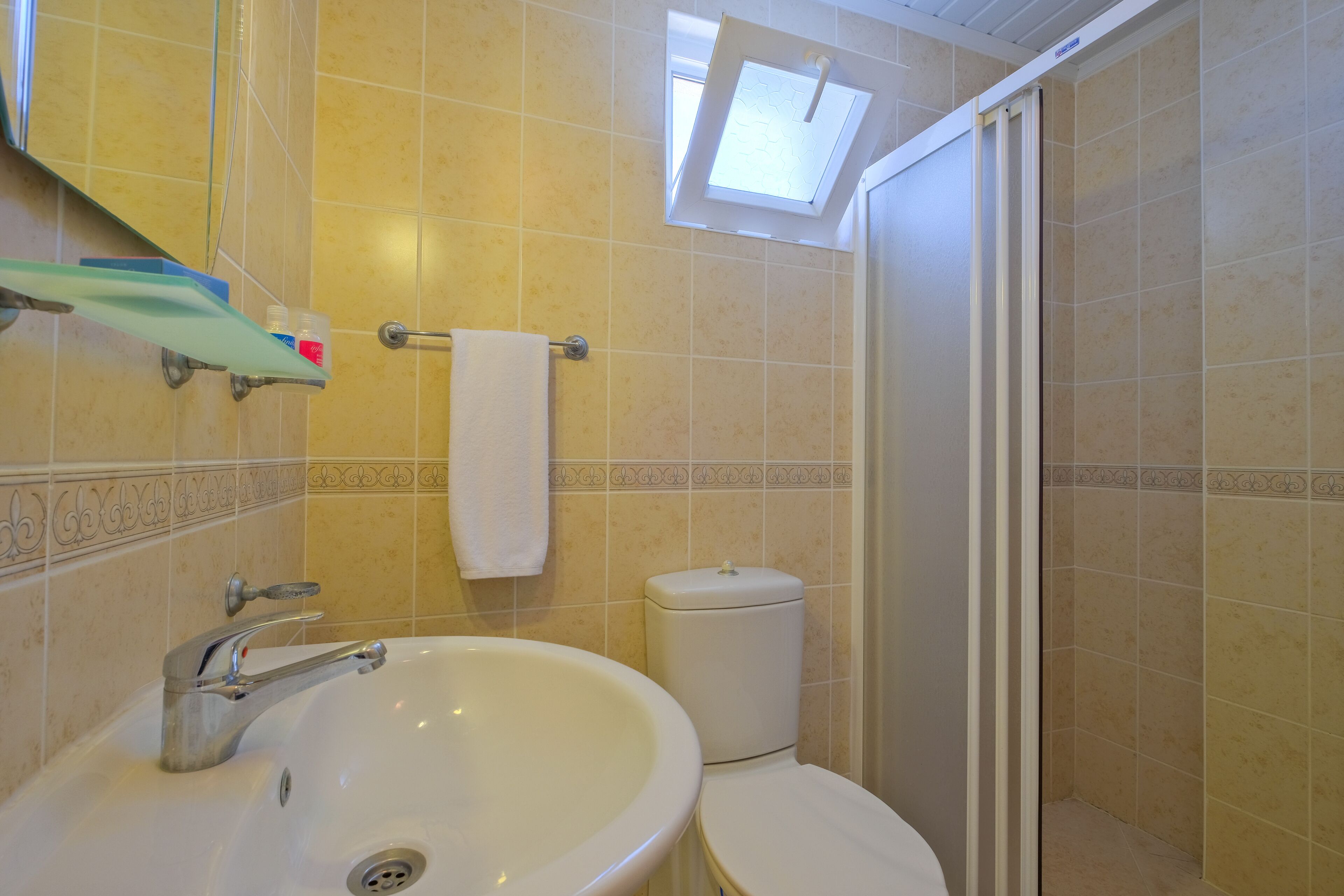 A bathroom with a sink, toilet, and shower.