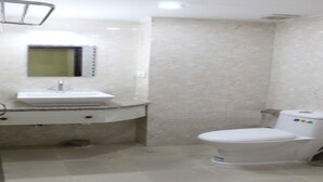 A bathroom with a white sink, mirror, and toilet. - MeroStay 021 Hotel Ganga Sagar (Kathmandu)