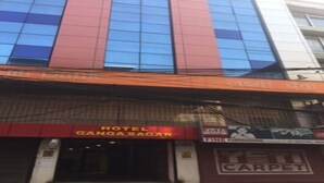 A hotel with a red and blue facade, a visible sign for 'Hotel Gangasagar', and a 'Fine Carpet' sign indicating a carpet service. - MeroStay 021 Hotel Ganga Sagar (Kathmandu)