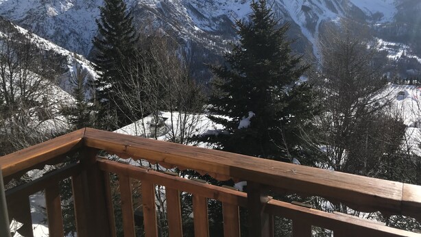 A mountain view with a wooden deck.