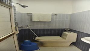 Un baño pequeño con inodoro, lavamanos y ducha.