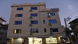 Un edificio de varios pisos con varias ventanas y unidades de aire acondicionado.