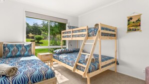 Ein Schlafraum mit Etagenbetten und Blick auf einen Garten.