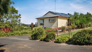 Ein eingeschossiges Haus mit Satteldach, Solaranlage und einer Veranda.