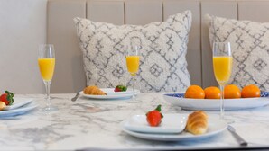 A breakfast table with orange juice glasses, a croissant, strawberries, and a plate of oranges. - Monowai Heights (St Ives)