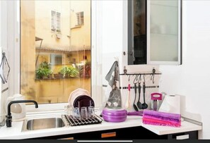 Enjoy a kitchen with a sink, dish rack, blender, and utensils, offering a view of the surrounding area.