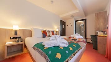 Ein Hotelzimmer mit Bett, Schreibtisch, Stuhl, Lampe und Telefon.