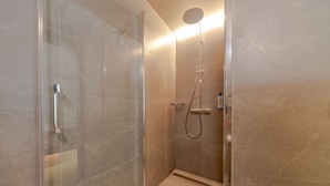 A glass-enclosed shower with a handheld showerhead and a wall-mounted faucet. - Kazakiwi (Luxembourg City)