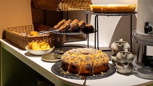 A buffet table with various baked goods, including a bundt cake, bread, and pastries. - Kazakiwi (Luxembourg City)