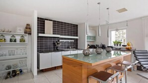 A modern kitchen with a central island, bar stools, and a dining area. - Huge Penthouse - Birmingham Central - Balcony (Birmingham)