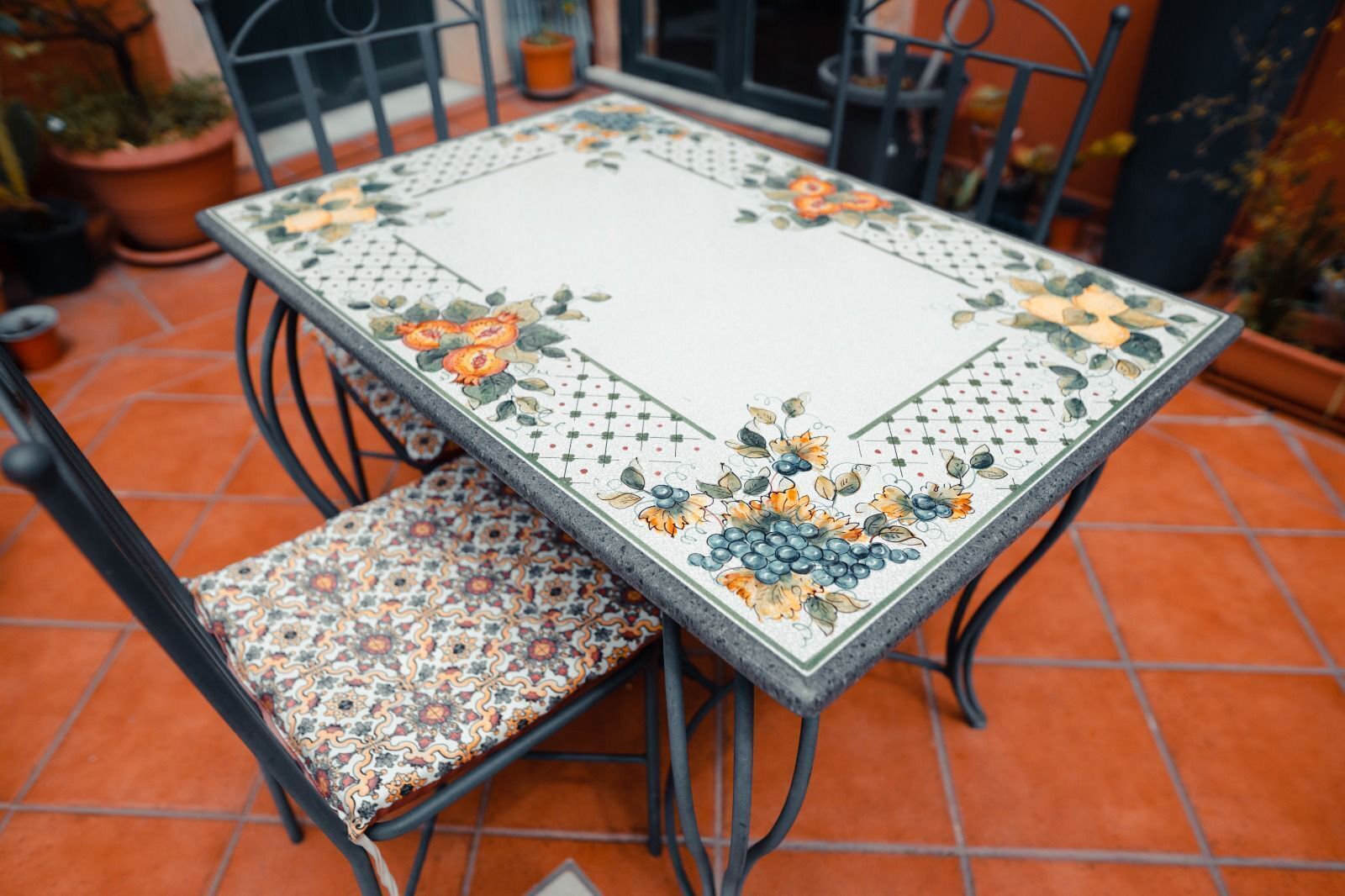 Una mesa cuadrada con un estampado floral, acompañada de una silla a juego con un cojín estampado.
