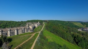 Een modern hotel met meerdere verdiepingen, een centrale binnenplaats en een prachtig uitzicht op een bebost gebied.
