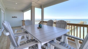 A covered outdoor dining area with a view of the ocean and a pier. - Soggy Pollards 5 Bedroom Home by RedAwning (Rockport)