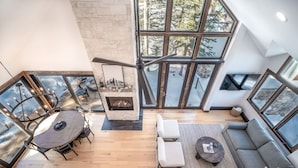 A spacious living area with a fireplace, a dining table, and a sofa. - Winterleaf 4 Bedroom Home by RedAwning (Telluride)
