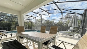 Ett takförsett utomhusområde med en pool, sittplatser och parasoller.