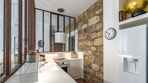 A modern kitchen with a stone accent wall, a built-in oven, and a large window with a view. - NEW-Hyper Centre-Cozy Chic-Renovated apartment with all comforts-AC-Balconnet-asc-Park (Nice)