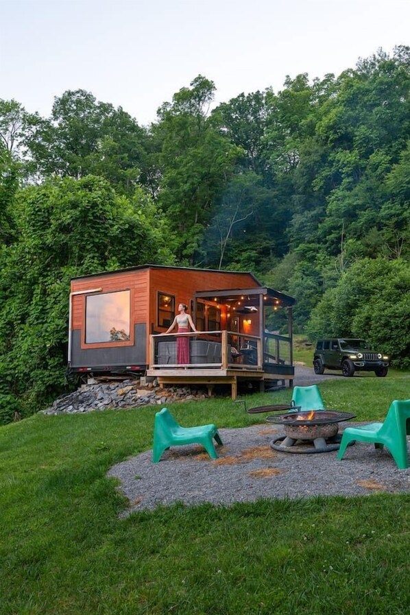 Une petite cabane dotée d’une terrasse, d’un foyer extérieur et de sièges pour profiter de l’extérieur.