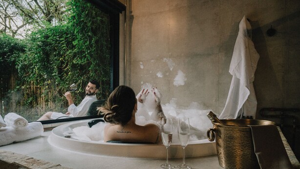 A spa setting with a bathtub, a towel, and a glass of water. - Pousada LaPianta  (Camanducaia)