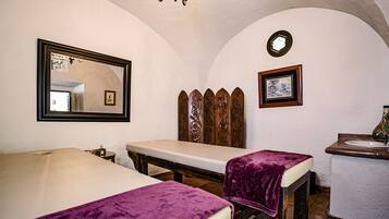 Classic design with a vaulted ceiling, featuring a large mirror above the bed and a wooden bench with a blanket.