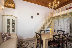 A dining area with a wooden table, chairs, and a chandelier.