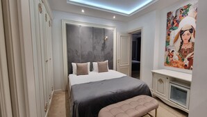 Ein Schlafzimmer mit einem Bett, einer Sitzbank, einem Kleiderschrank und einem Gemälde.