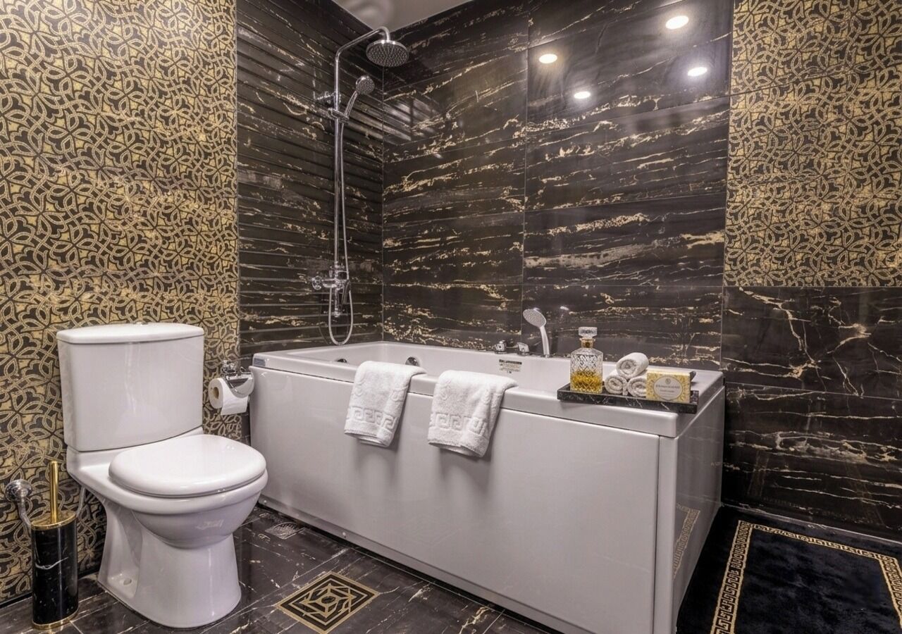 A modern bathroom with a toilet, bathtub, and shower.