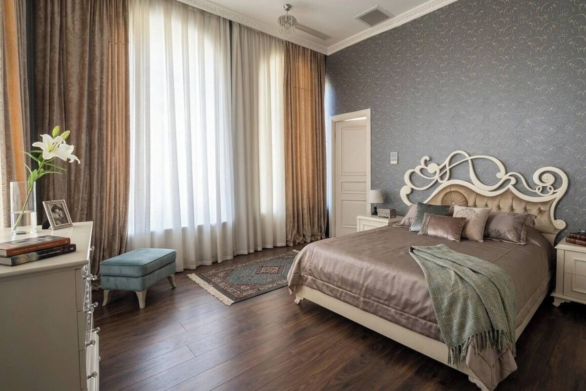 Una camera da letto con un letto grande, un comodino, una cassettiera e una finestra con tende.