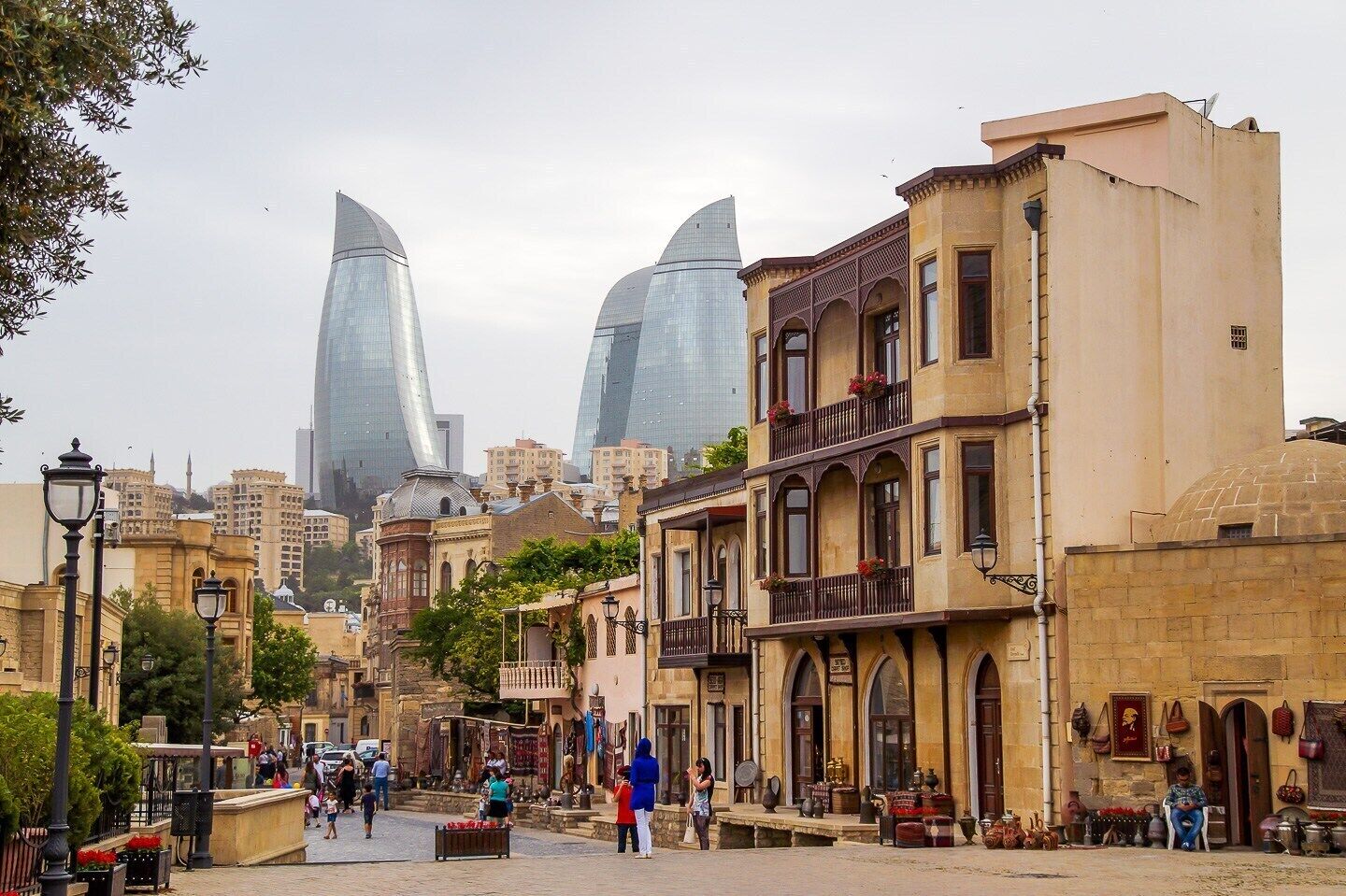 A street with traditional buildings and modern skyscrapers in the background.
