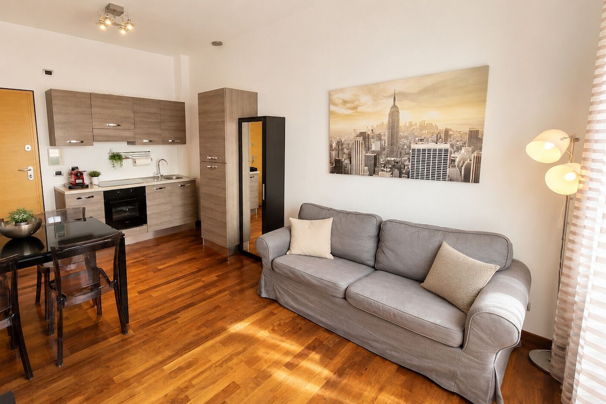 A compact living space with a dining area, kitchenette, and a sofa.