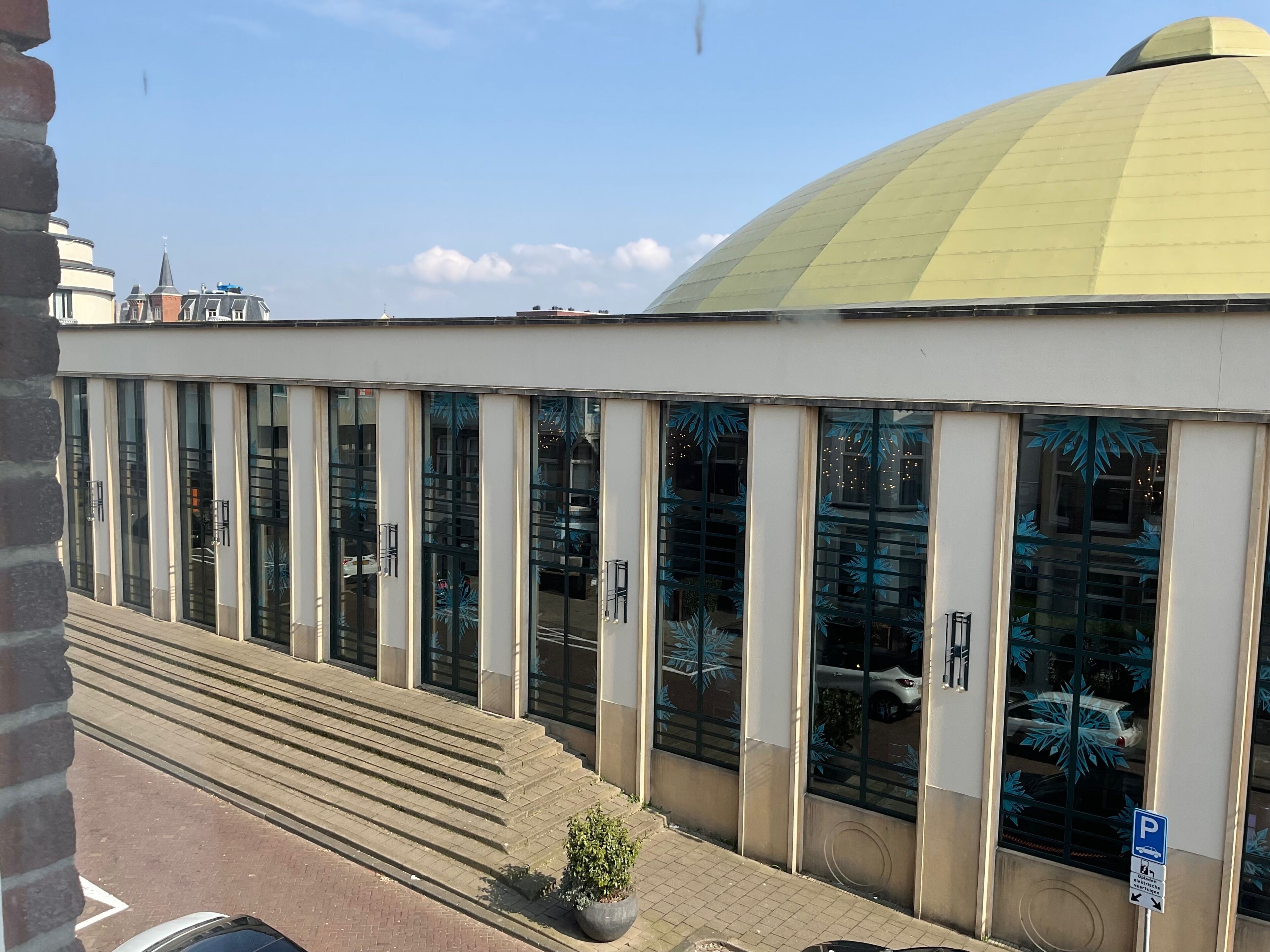 Um edifício com uma grande cúpula amarela e várias janelas altas.