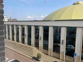 Un edificio con una cúpula amarilla grande y una serie de ventanas altas.