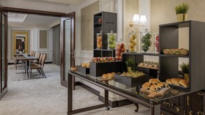 A hotel dining area with a buffet setup, including various food items and a seating arrangement. - Riviera Rayhaan by Rotana Doha (Doha)