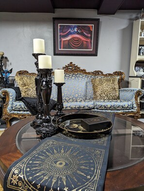 A room with a blue sofa, ornate black candelabras, and a decorative tray on a glass table. - See nearby attractions, Visit Little Sahara, great salt plains, Alabaster Cavern (Alva)