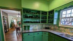 A kitchen with green cabinets, a wooden floor, and a tiled backsplash. - See nearby attractions, Visit Little Sahara, great salt plains, Alabaster Cavern (Alva)