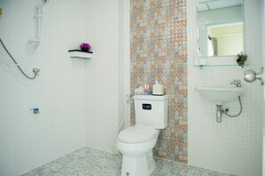 A bathroom with a white toilet, a shower, a sink, and a mirror. - Be my guest36 (Bangkok)