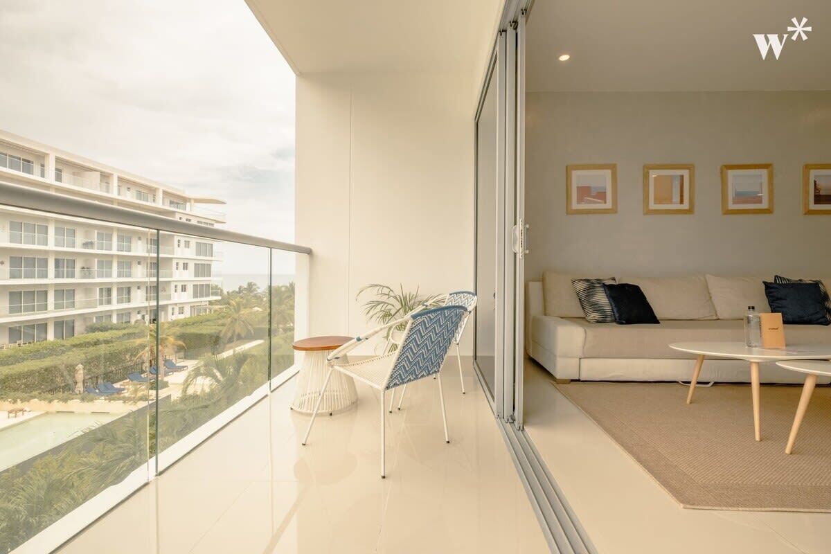 A modern living room with a balcony, a sofa, a coffee table, and a chair.