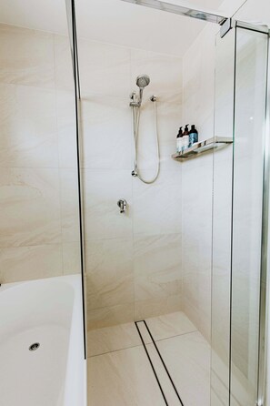 Bathtub, hair dryer, towels, shampoo